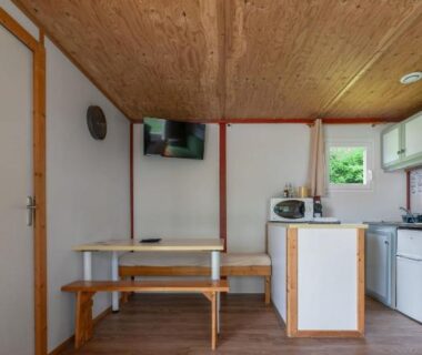 Intérieur avec coin repas et kitchenette dans le cottage du Camping Le Mont Libre