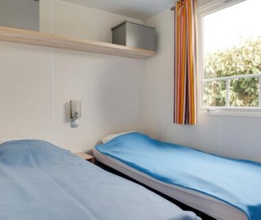 Chambre avec deux lits et fenêtre au Camping Le Moténo Maeva
