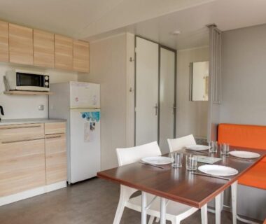 Intérieur avec kitchenette table et banquette dans le mobil-home du Camping Le Moténo Maeva
