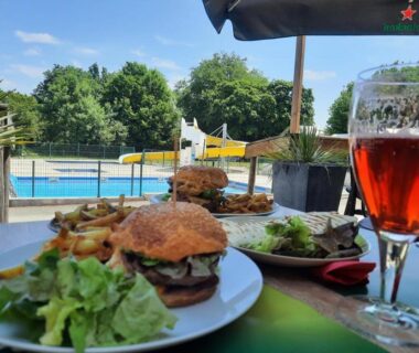Terrasse avec repas et piscine au Camping Le Moulin des Effres