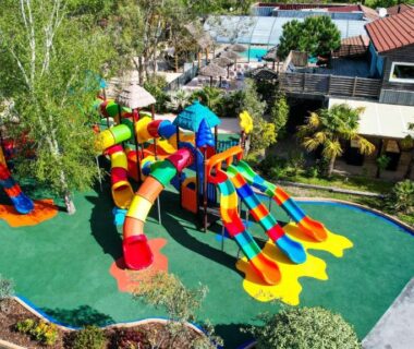 Aire de jeux avec toboggans colorés près de la piscine au Camping Le Paradis Carcans Lacanau
