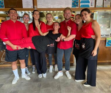 Intérieur du bar avec l'équipe en uniforme au Camping Le Perpetuum