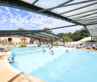 Piscine couverte avec nageurs et transats au Camping Le Petit Rocher