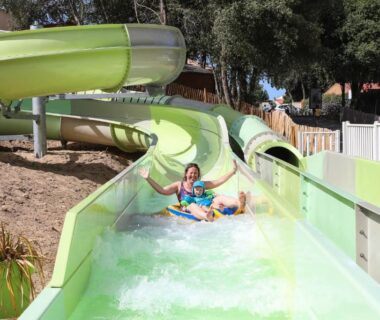 Toboggan aquatique vert avec personnes en descente au Camping Le Petit Rocher
