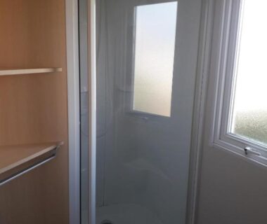 Salle de bain avec cabine de douche et fenêtre dans le mobilhome du Camping Le Picard