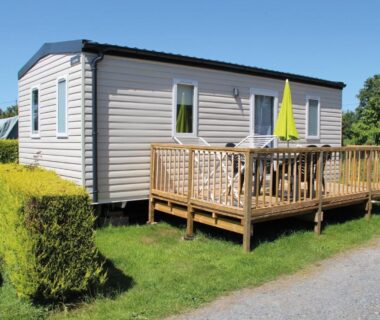 Mobil-home sur pelouse avec terrasse et parasol au Camping Le Picard