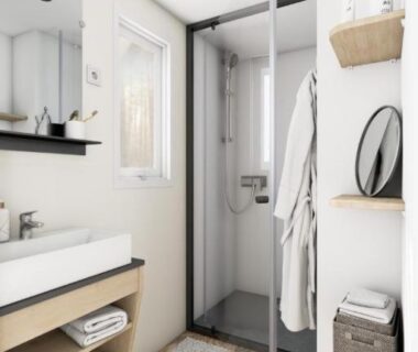 Salle de bain avec cabine de douche et lavabo au Camping Le Puits Rochais