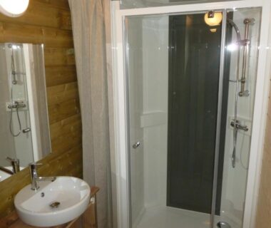 Salle de bains avec cabine de douche et lavabo dans le Camping Le Relais de la bresque