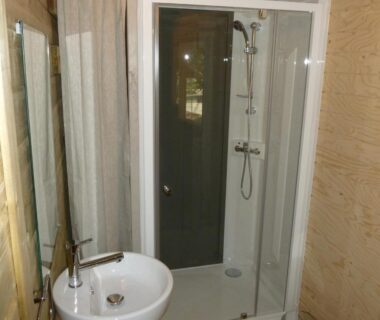 Salle de bain avec cabine de douche et lavabo au Camping Le Relais de la bresque