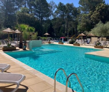 Piscine extérieure avec chaises longues et parasols au Camping Le Relais de la bresque