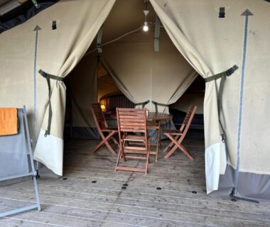 Terrasse en bois avec table et chaises dans la tente au Camping Le Sans Souci
