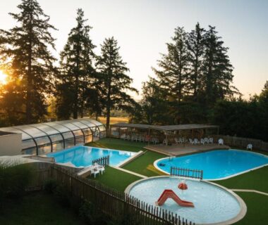 Piscines extérieures et bassin couvert dans un espace boisé du Camping Le Sequoia