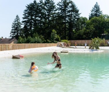 Bassin lagon avec deux personnes se baignant au Camping Le Sequoia