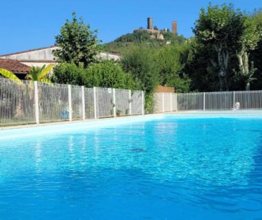 Piscine extérieure aux eaux bleues avec clôture et végétation au Camping Le Soulhol