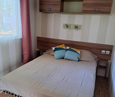 Chambre avec lit double et rangements au Camping Le Soulhol
