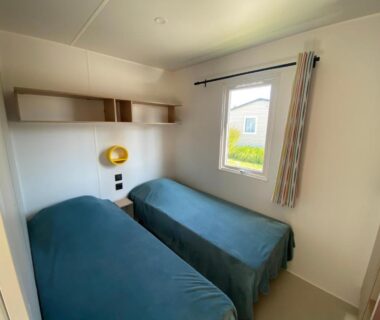 Chambre avec deux lits étagère et lampe au Camping Le Tarteron