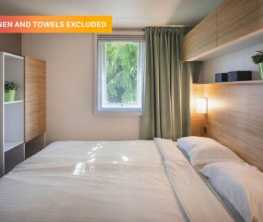 Chambre avec lit double et fenêtre dans le camping Le Ty Nadan - Roan
