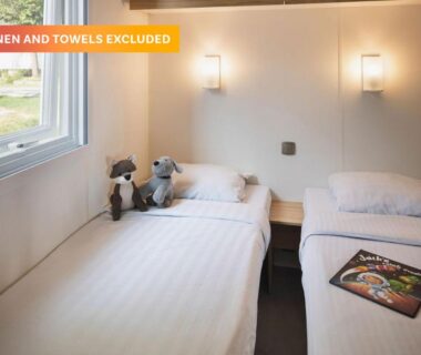 Chambre avec deux lits simples peluches et fenêtre dans le Camping Le Ty Nadan - Roan