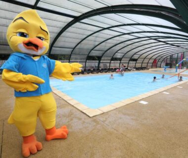 Piscine couverte avec mascotte canard et baigneurs au Camping Le Val de Trie
