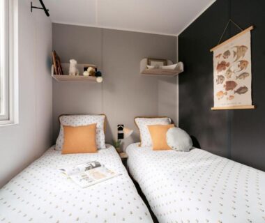 Chambre avec deux lits simples et tenture poissons au Camping Le Walric