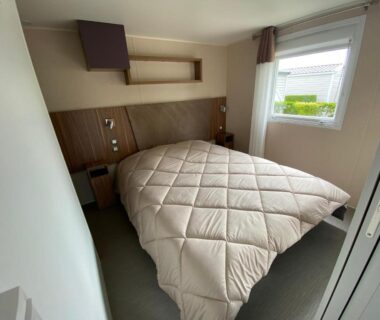 Chambre avec lit double et fenêtre dans le locatif du Camping Les 2 Plages