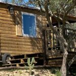 Dans un sous-bois roulotte en bois sur remorque au Camping Les Amandiers