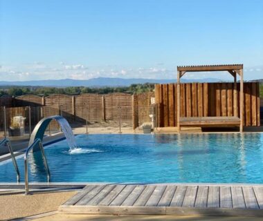 Piscine extérieure avec deck et pergola au Camping Les Amandiers