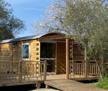 Chalet en bois avec terrasse ombragée au Camping Les Amandiers