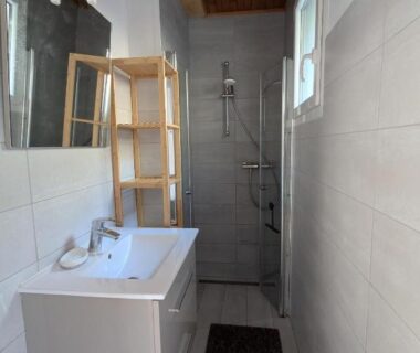 Salle de bain avec douche et vasque du Camping Les Berges Du Doux