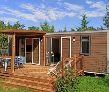 Mobil home avec terrasse en bois et salon de jardin au Camping Les Charmes