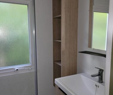 Salle d'eau avec lavabo et miroir au Camping Les Chênes Verts