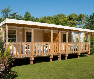 Sur pelouse mobil home avec terrasse en bois au Camping Les Chèvrefeuilles