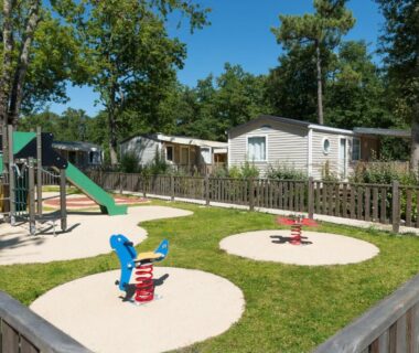 Aire de jeux pour enfants avec mobil-homes au Camping Les Chèvrefeuilles