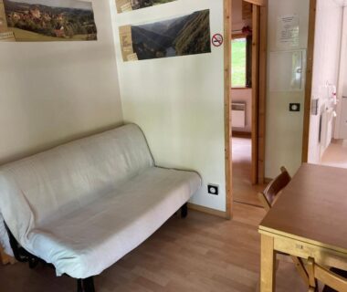 Salon avec canapé et table dans le mobil-home du Camping Les Etoiles