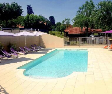 Piscine extérieure avec parasols et transats au Camping Les Etoiles