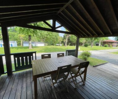 Terrasse couverte avec table et chaises au Camping Les Etoiles