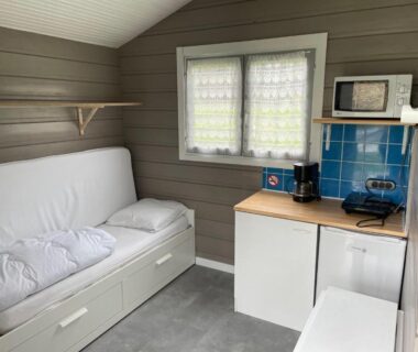 Intérieur kitchenette avec banquette et fenêtre dans le logement du Camping Les Etoiles
