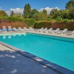 Piscine extérieure avec transats au Camping Les Fontaines