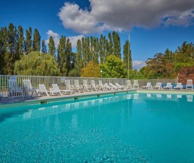 Piscine extérieure avec transats au Camping Les Fontaines