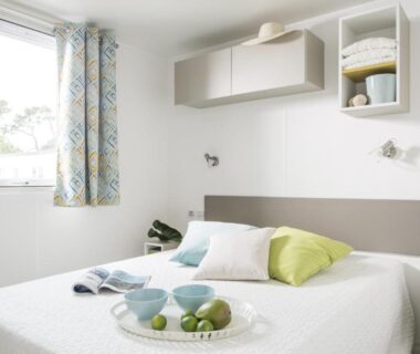 Chambre avec lit double et fenêtre dans le logement du Camping Les Garennes
