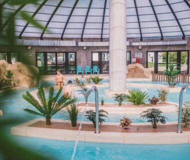 Piscine couverte avec palmiers et fontaines au Camping Les Garennes