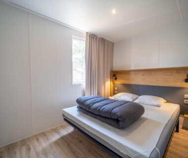 Chambre intérieure avec lit double dans le Camping Les Genêts
