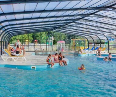 Piscine couverte avec nageurs et transats au Camping Les Goélands Carnac
