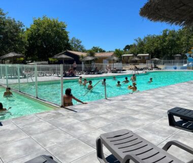 Piscine extérieure avec baigneurs et transats au Camping Les Goélands Maeva