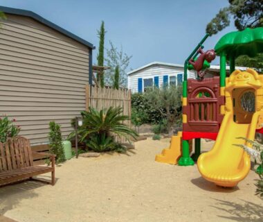 Aire de jeux avec toboggan et banc au Camping Les Jardins d Agathe