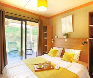 Chambre double avec baie vitrée et terrasse au Camping Les Lavandes
