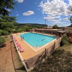Piscine extérieure avec transats au Camping Les Lavandes