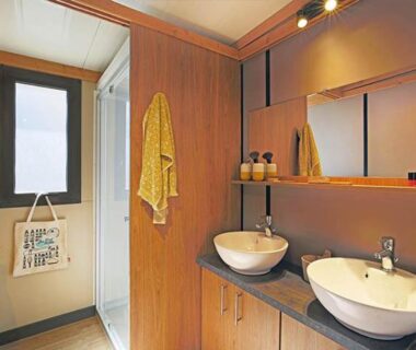 Salle de bain avec deux vasques et serviettes au Camping Les Lavandes