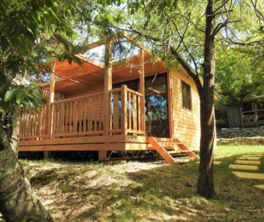 Emplacement ombragé avec bungalow en bois et terrasse au Camping Les Lavandes
