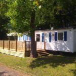 Emplacement herbeux avec mobil-home et terrasse en bois au Camping Les Lupins